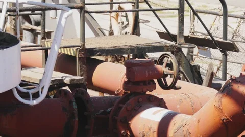 Black valve in thin red rusty pipes in sea ship. Machinery and equipment of a Stock-Footage 114625605