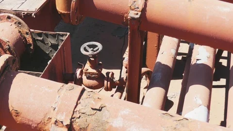 Black valve in thin red rusty pipes in sea ship. Machinery and equipment of a Stock-Footage 114625633