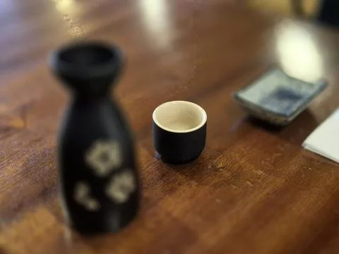 Black vape device and small cup on wooden table Stock Photos