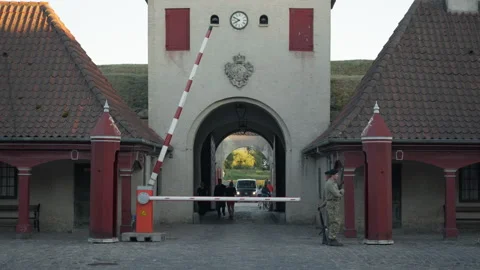 Black vehicle approaches the closed security boom barrier at Kastellet gate Stock Footage 345590825