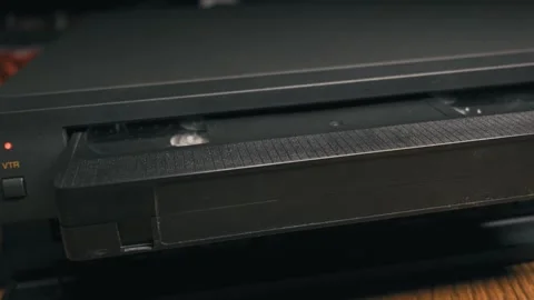 Black VHS Cassette Tape Ejects From Retro VCR Player Video stock 330272754