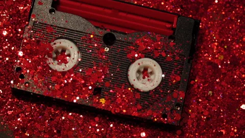 Black video cassette on the background of red glitter Stock Footage 99986495