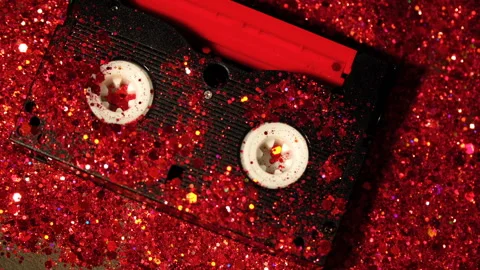 Black video cassette on the background of red glitter Stock Footage 99987012