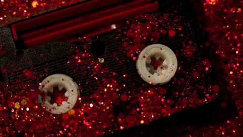 Black video cassette on the background of red glitter Stock Footage 99991127