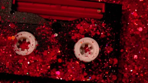 Black video cassette on the background of red glitter Stock Footage 165121844