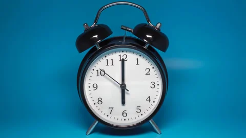 Black vintage alarm clock with two bells on blue background Stock Footage 168936173