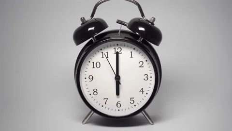 Black vintage alarm clock with two bells on gray background Stock Footage 169399512