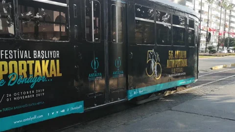 A black vintage tram passes through Konyaalti Caddesi street in Antalya Stock Footage 224711966