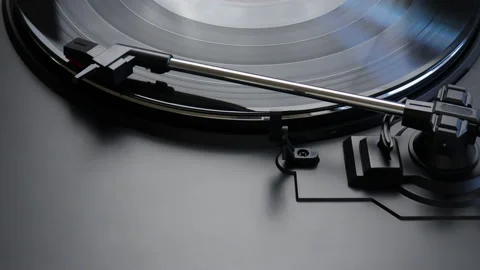 Black vinyl record spinning on a turntable - close up of tonearm playing the LP Stock Footage 145890415