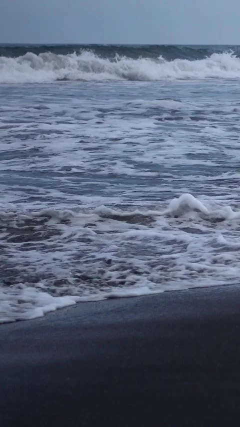 Black volcanic sandy beach with wave coming up, from side Stock Footage 222982703