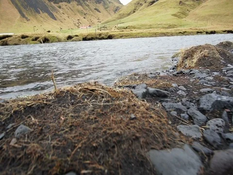 Black volcanic soil around flowing river. Landscape scenic of Iceland Stock Footage 78992484