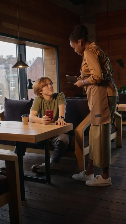Black Waitress Taking Order from Male Customer in Coffee Shop 動画素材 344372276