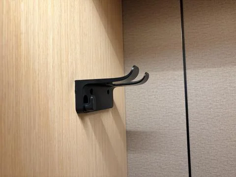 Black wall hook on a wooden surface. Stock Photos