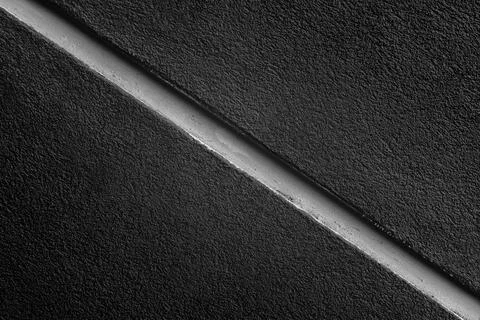 A black wall texture divided in half by a line Stock Photos