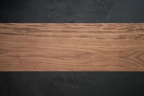 Black walnut wood background of solid board in front of concrete wall Foto stock