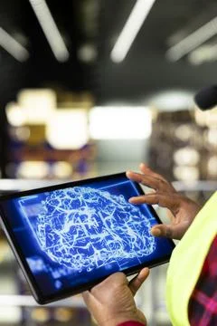 Black warehouse staff operating high-tech AI systems on a tablet Stock Photos
