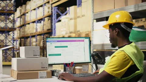 Black warehouse staff verifying cargo goods during import export process Stockbeeldmateriaal 315708587