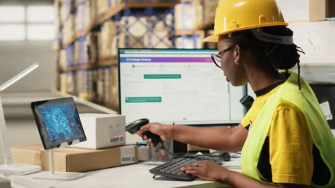 Black warehouse worker managing inventory logistics with AI virtual assistant Stock Footage 315706940