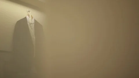 Black wedding jacket hanging on the wall Shooting through yellow blur Stock Footage 95244683