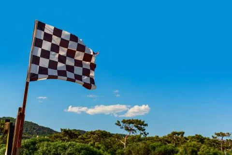 Black white checkered wind flag on tropical beach Stock Photos