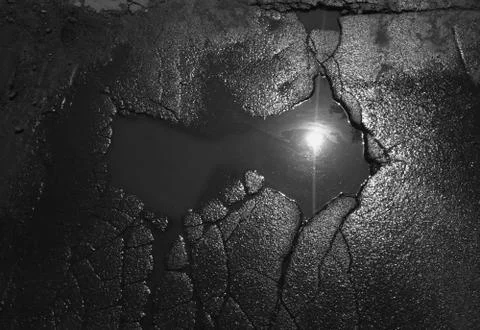 Black &amp; white sun reflection in puddle background Foto stock