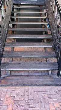 Black wide staircase going down to the brick floor Stock Photos