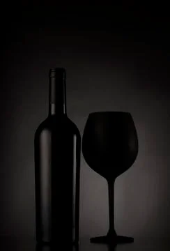 Black wine bottle and black glass of wine Stock Photos