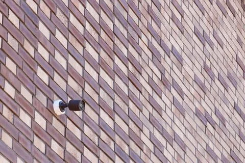 Black wireless CCTV security camera for area surveillance placed on brick w.. Stock Photos