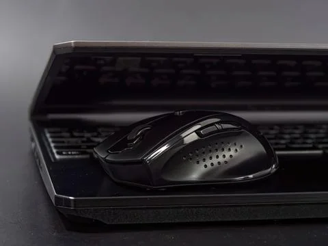 Black wireless computer mouse on a laptop keyboard Stock Photos