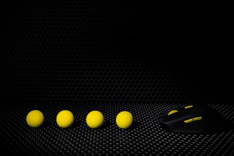 Black wireless computer mouse with yellow buttons on a background of black la Stock Photos