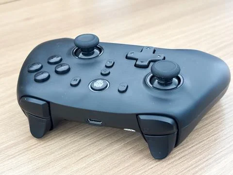 Black Wireless Gaming Controller Modern Ergonomic Design on Wooden Background Stock Photos