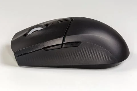 Black wireless optical computer mouse on gray background, side view Stock Photos