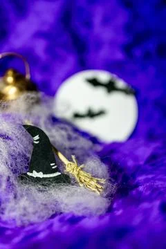 Black witch's hat and witch's broom on a purple background with full moon. Stock Photos