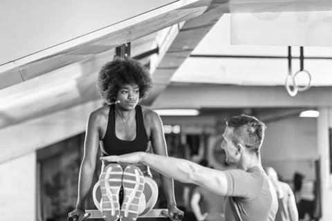 Black woman doing parallel bars Exercise with trainer Stock Photos