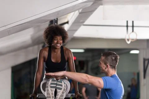 Black woman doing parallel bars Exercise with trainer Stock Photos