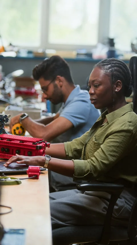 Black Woman Engineer Programming Robotic Vehicle on Laptop Vídeo Stock 343525674