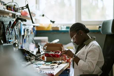Black Woman Engineer Testing Electronic Components in Lab Stock Photos