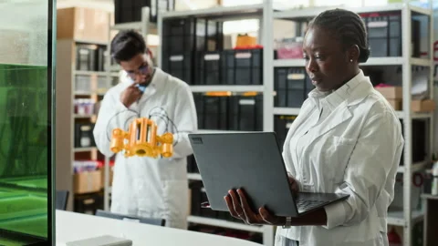 Black Woman Engineer Using Laptop in Robotics Development Lab Stock Footage 343517393