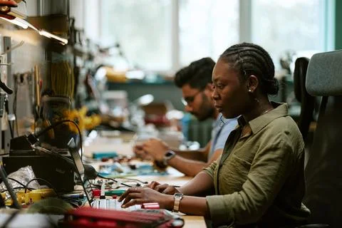 Black Woman Engineer Using Laptop in Electronics Laboratory 스톡 사진