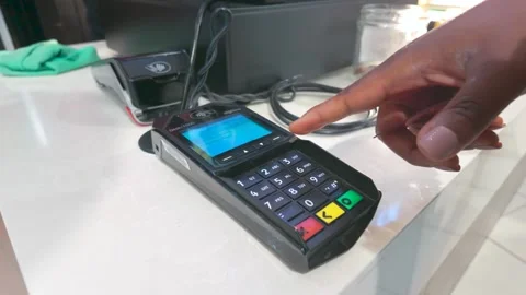 Black woman processes a transaction using a card on a payment terminal Stock Footage 319686286