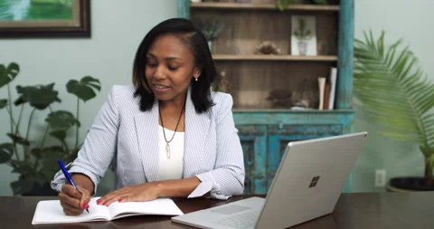 Black Woman Taking Notes on Virtual Interview from Home Video stock 131550507