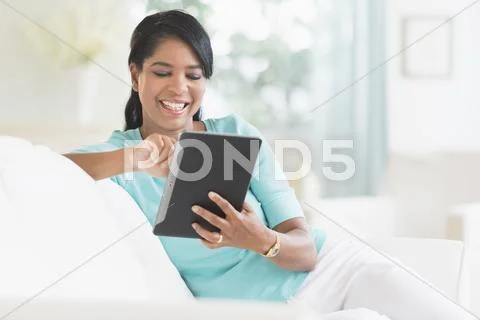 Black Woman Using Digital Tablet On Sofa