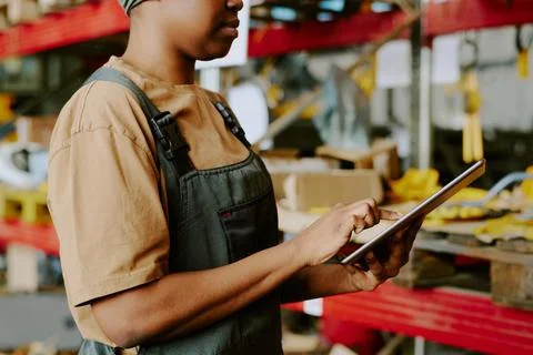Black Woman Using Digital Tablet at Work in Warehouse 写真素材