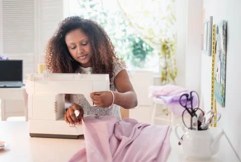 Black woman using sewing machine Stock Photos