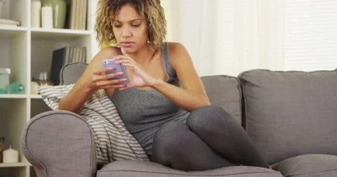 Black woman using smartphone on couch Stock-Footage 44498728