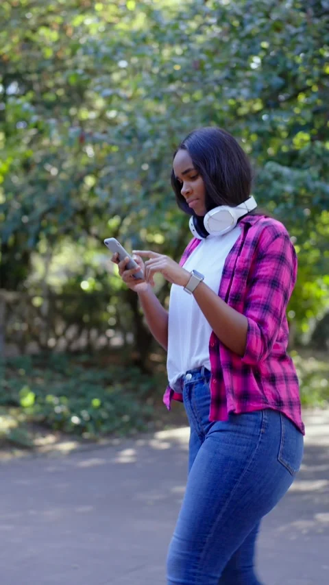 Black woman walking while using phone Vídeo Stock 252183112