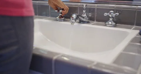Black woman washing hands in sink Stock Footage