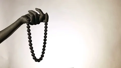 Black woman's hand with Black plastic beads. Fashion jewelry on a black paint Stock Footage 100682473