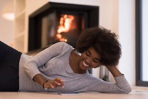 Black women using tablet computer on the floor beautiful young black women... Stock Photos