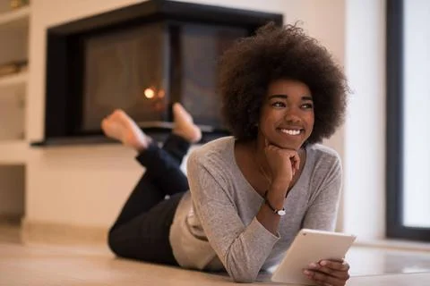 Black women using tablet computer on the floor beautiful young black women... Stock Photos
